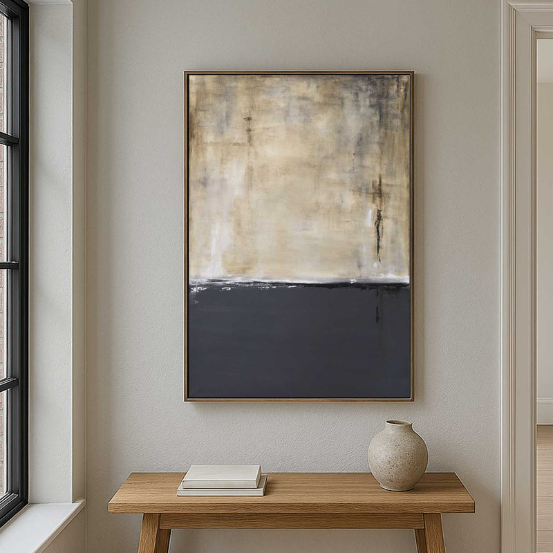 Abstract painting on a wall above a wooden table with a vase and books.